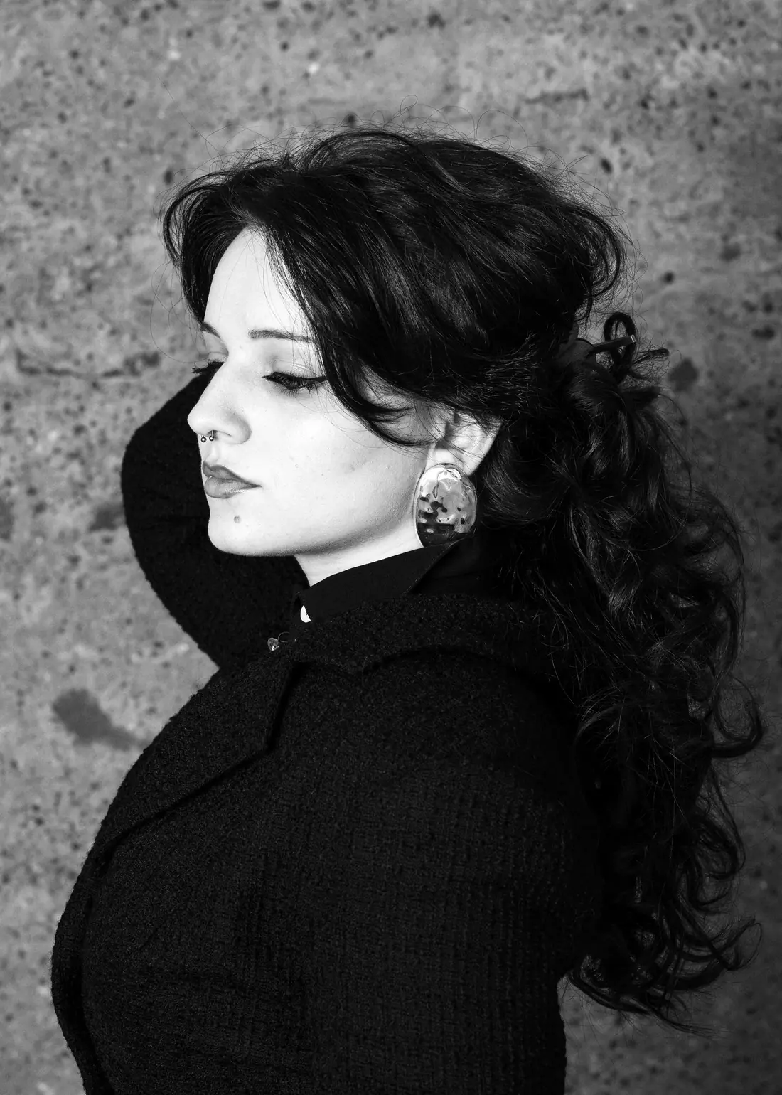 Costina Cindea in profile, a hand in her hair, wearing a large round earring.