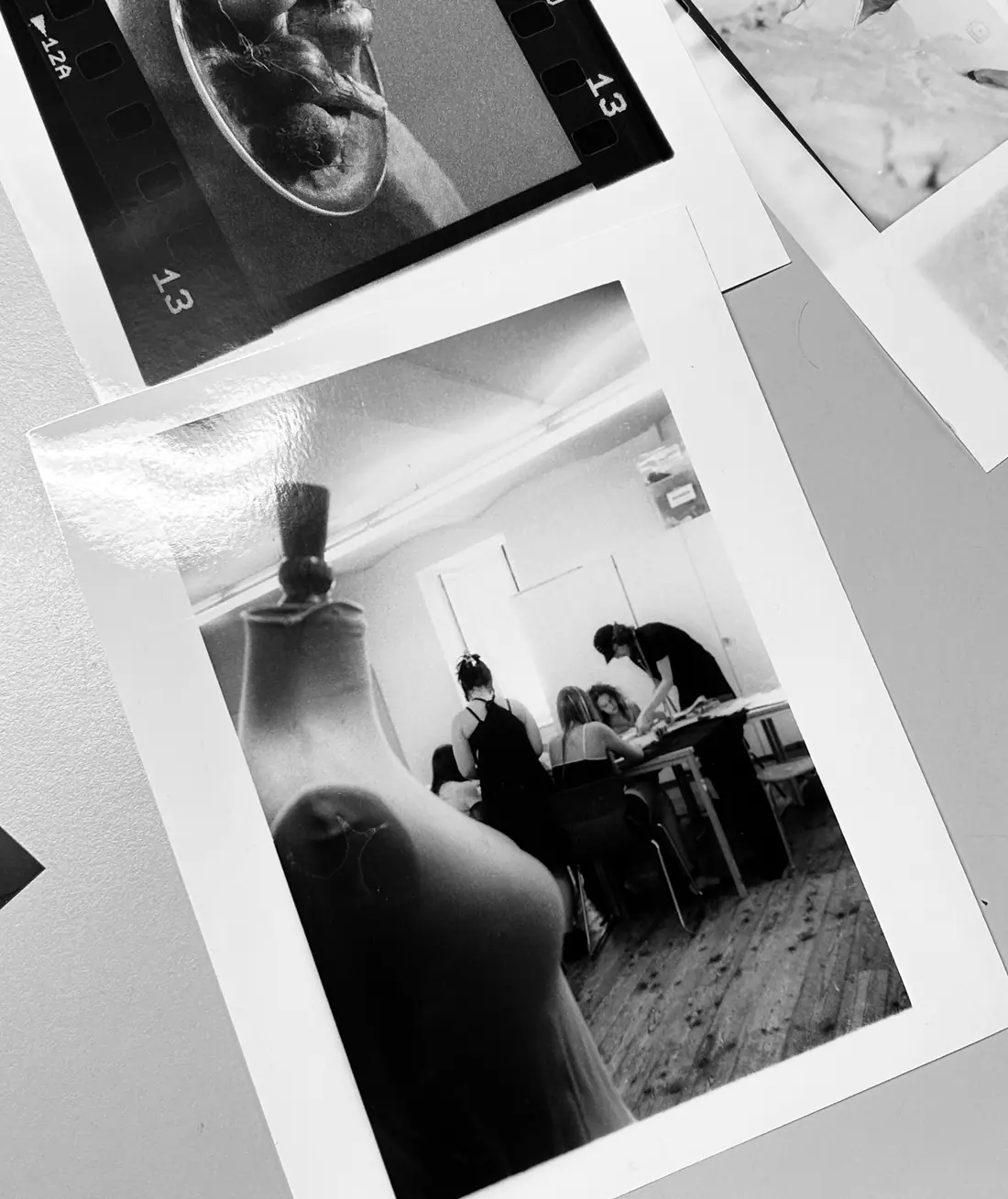 Analog prints from the workshop week spread across a table.